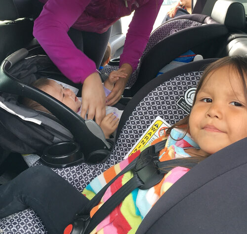 Adult adjusting car seats for young children
